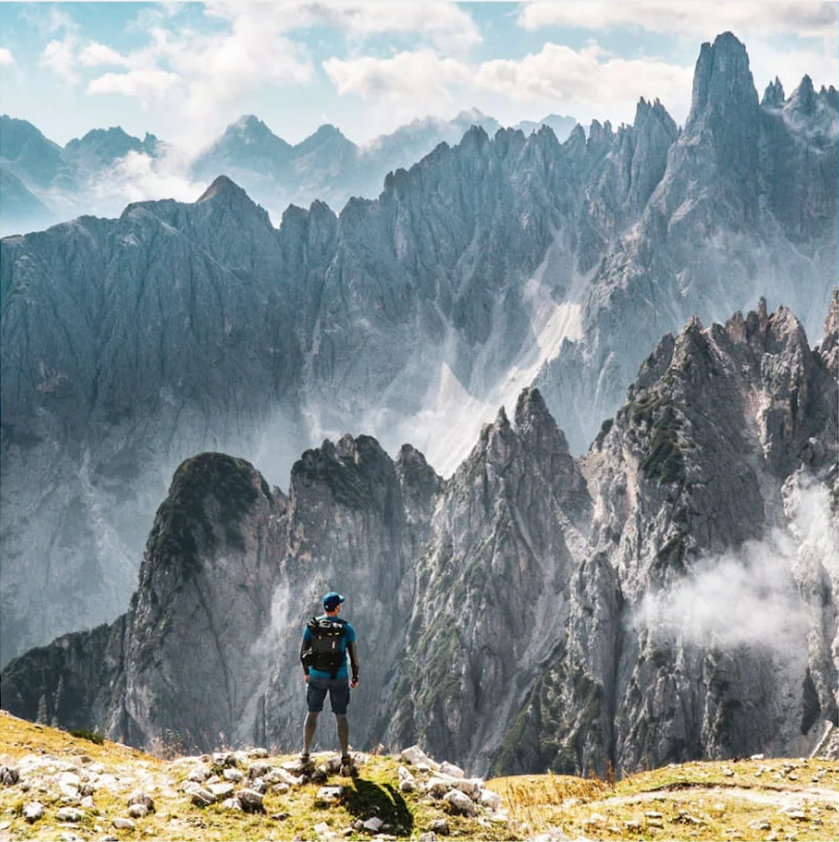 Una persona osserva le cime delle Dolomiti tra le nuvole