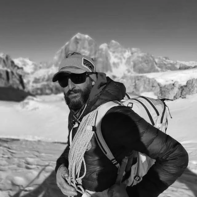 Tommi in montagna con zaino e occhiali da sole