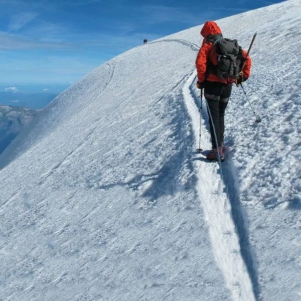 Alpinista in salita su un pendio innevato
